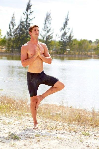 在湖边做瑜伽的年轻人