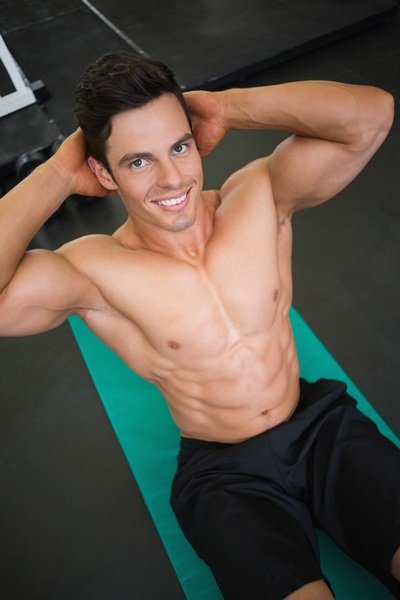 High angle view of muscular man doing abdominal crunches in gym
