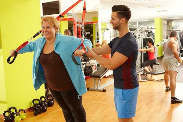 Overweight woman training with personal trainer