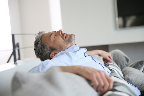 Middle-aged man having a restful moment relaxing in sofa