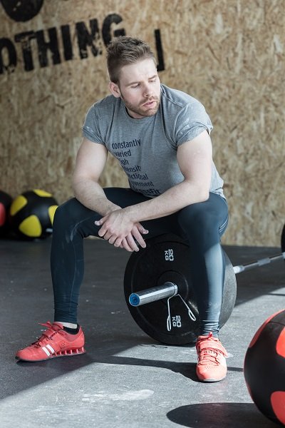 Weightlifter sitting on the barbell