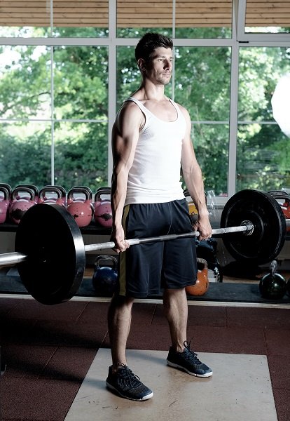 Athlete Fitness trainer working out / weight lifting in a gym