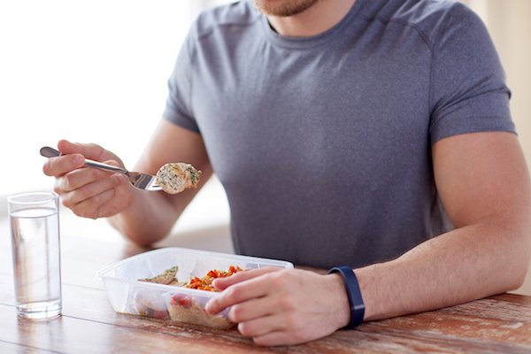 close up of man with fork and water eating food