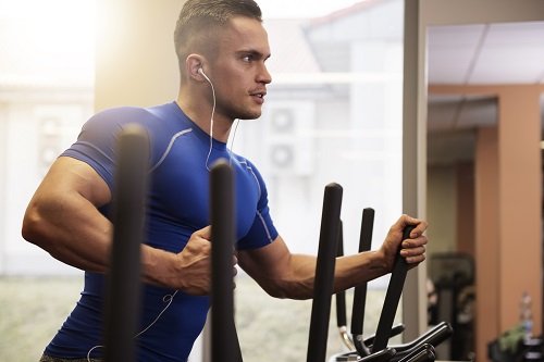 Handsome man on elliptical trainer
