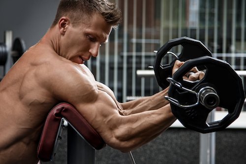 Muscular man training his arms