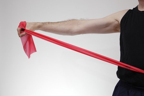 9755438 - a man is using his exercise bands to workout his arms.